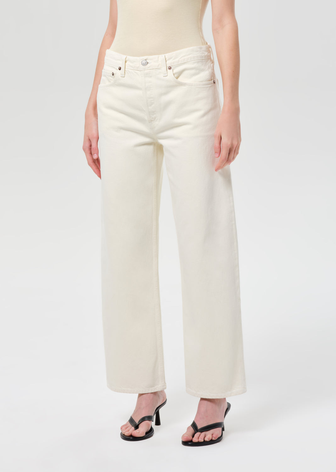 Person wearing white jeans on a plain background