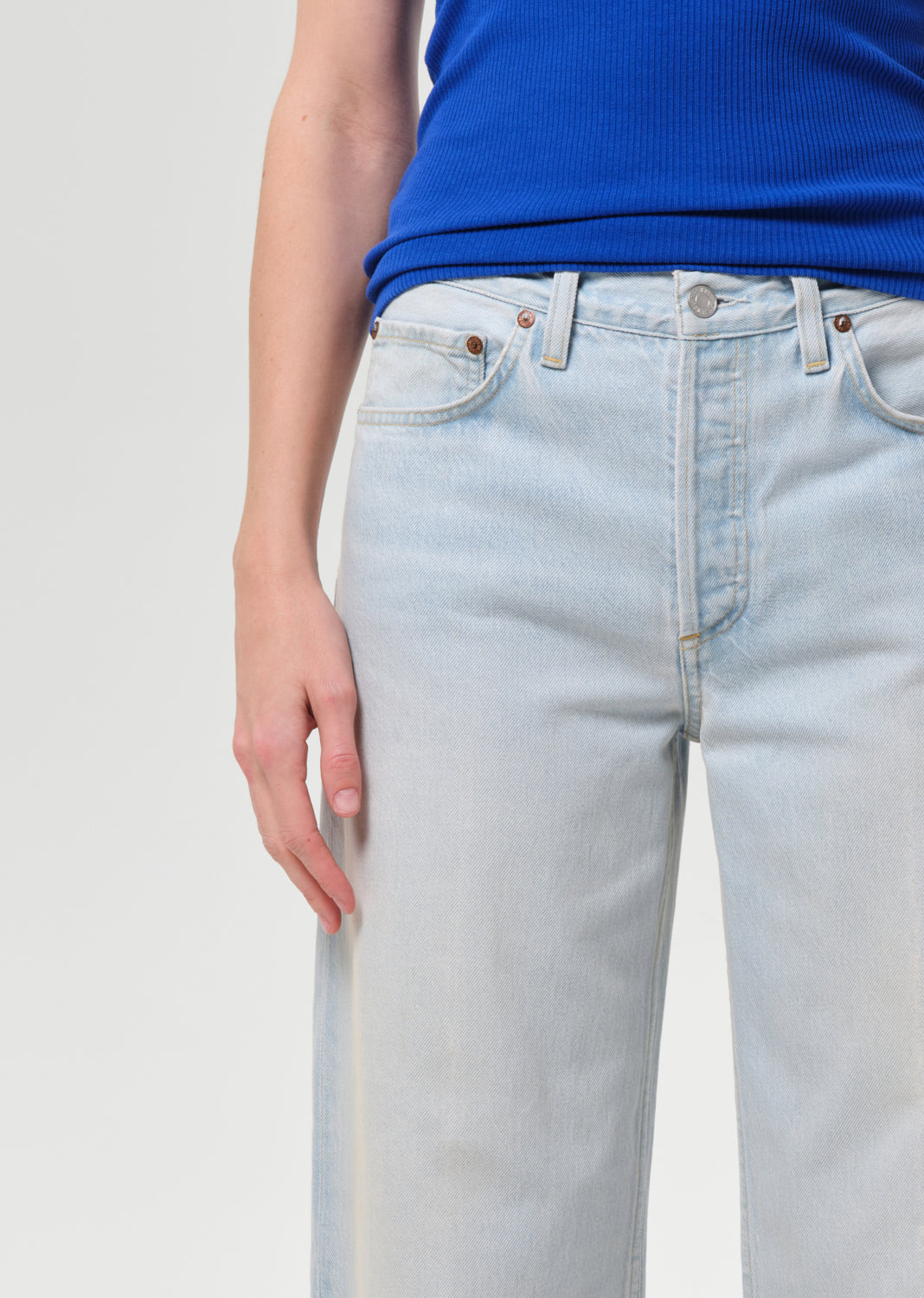 Light blue jeans worn by a person on a plain background