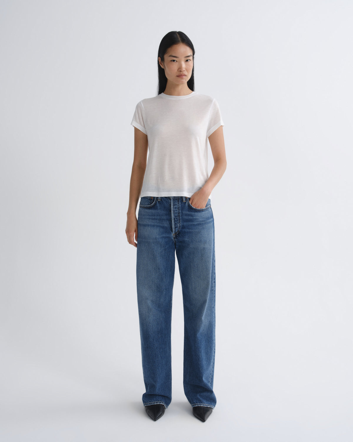 Person wearing a white t-shirt and blue jeans on a white background