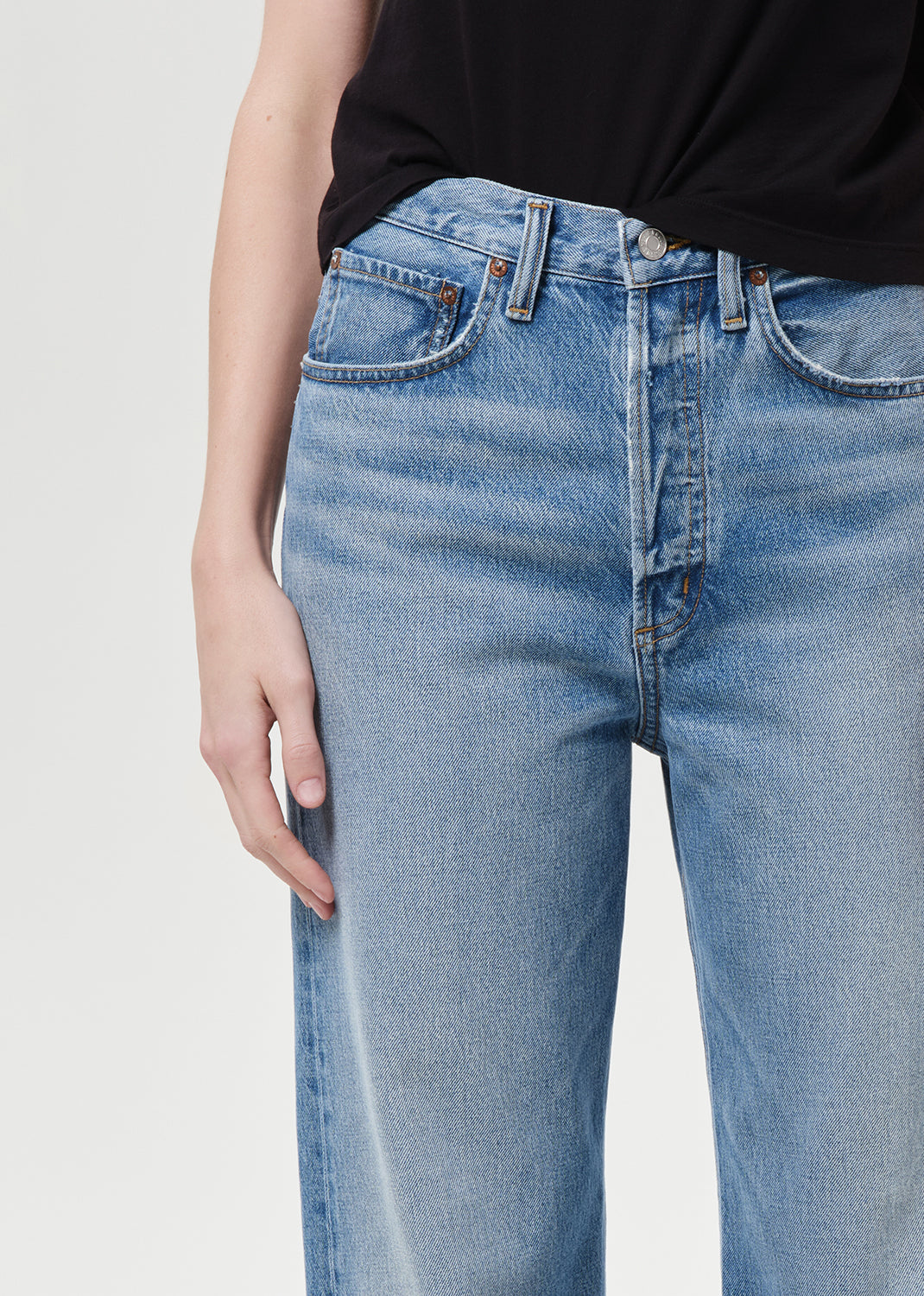 Light blue jeans worn by a person on a plain background