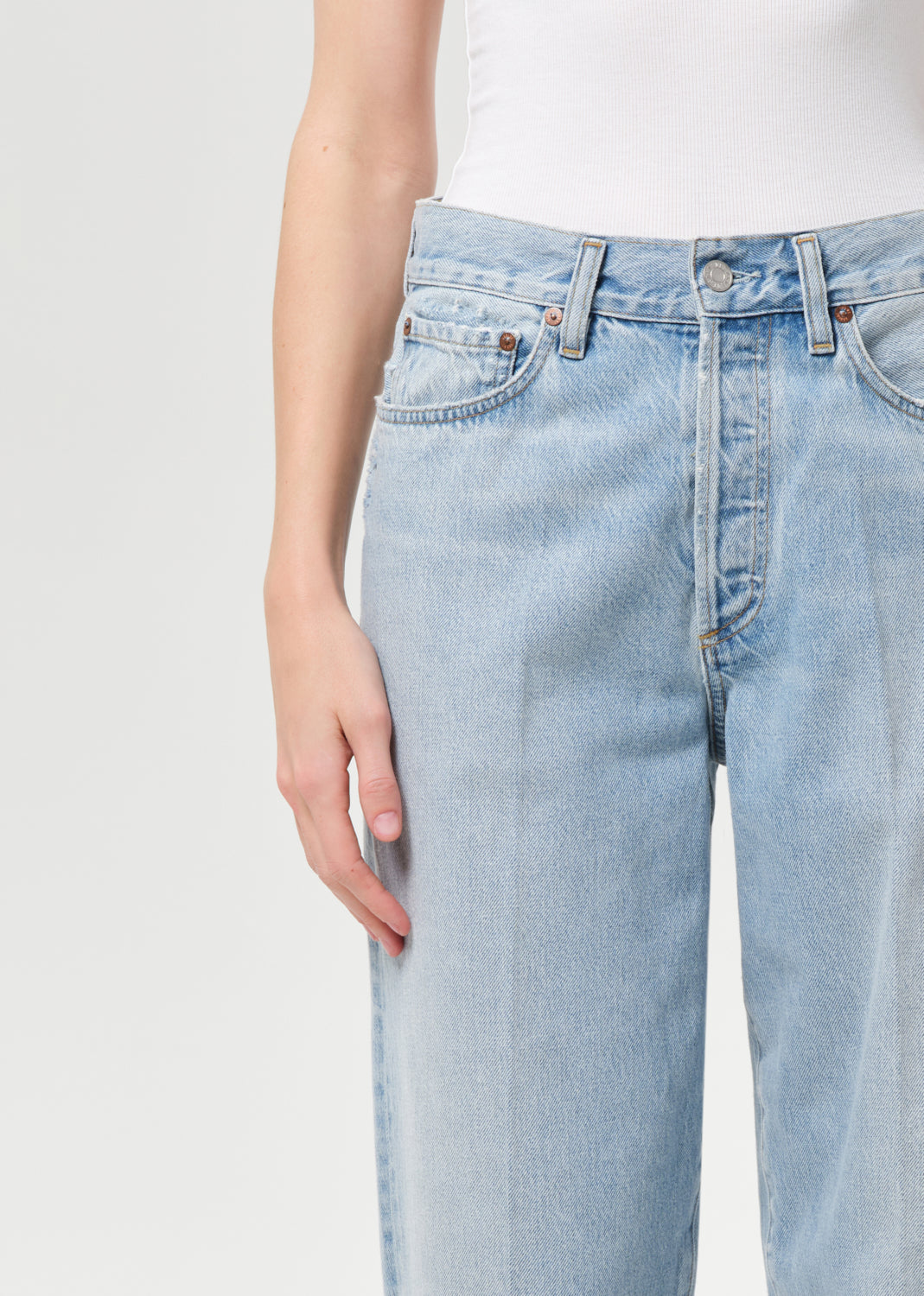 Light blue jeans worn by a person on a plain background