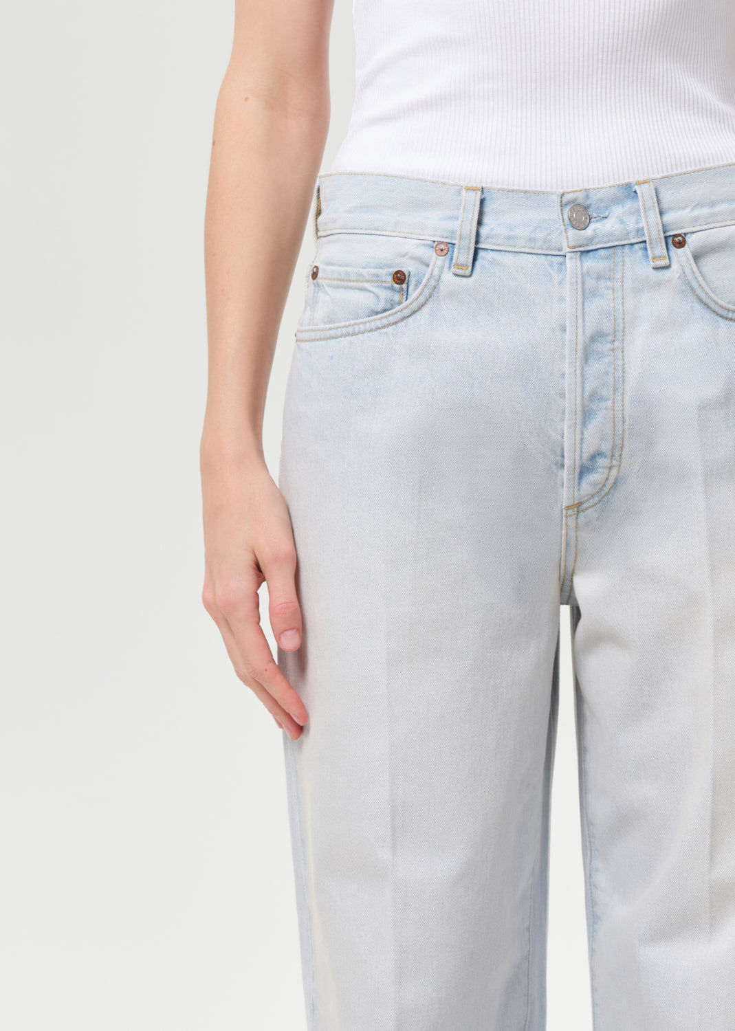 Light blue jeans worn by a person on a white background