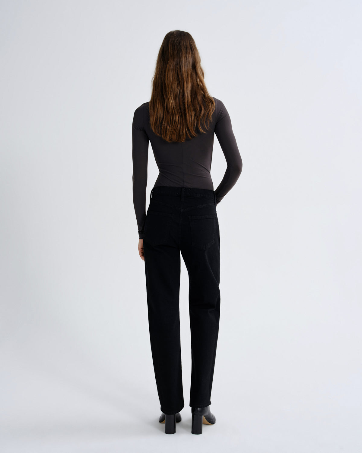 Person wearing black pants and a black top on a white background