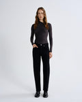 Woman wearing a black long-sleeve top and black pants on a white background