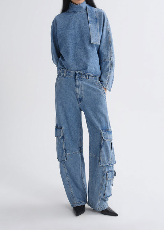 Person wearing a blue denim outfit with cargo pants on a grey background