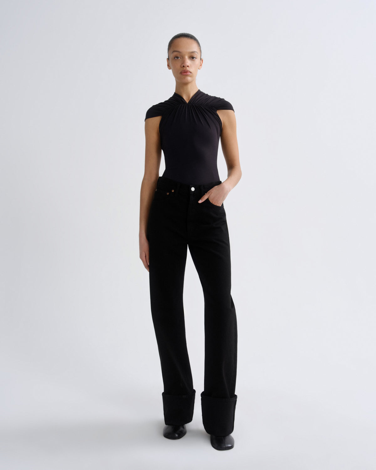 Person wearing a black outfit on a white background