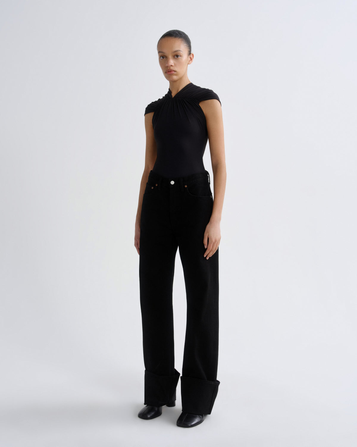 Person wearing a black outfit with a plain background