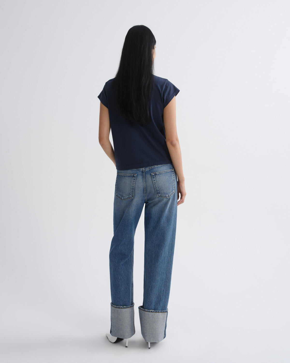Person wearing blue jeans with a white background