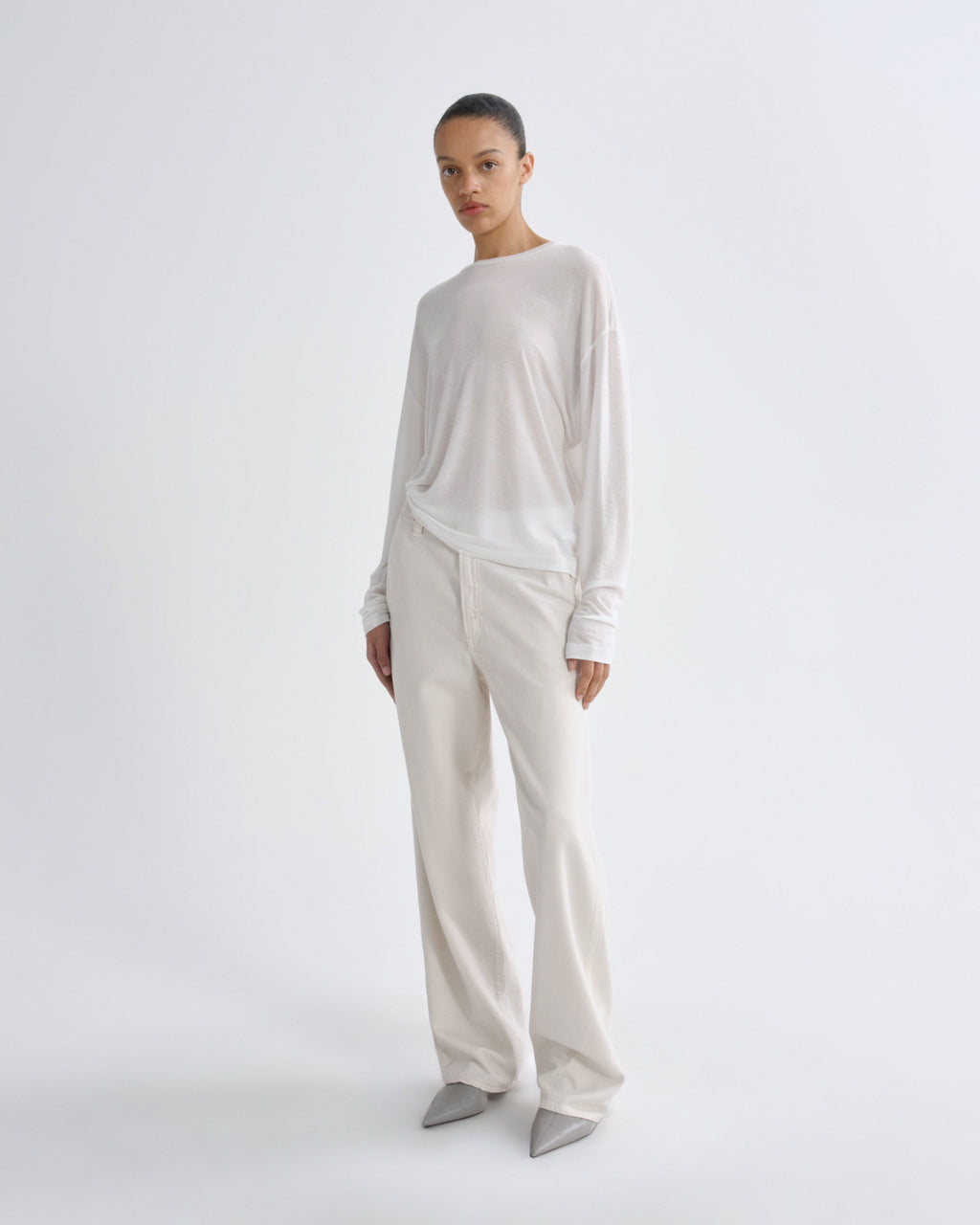 Person wearing a white long-sleeve top and pants on a white background