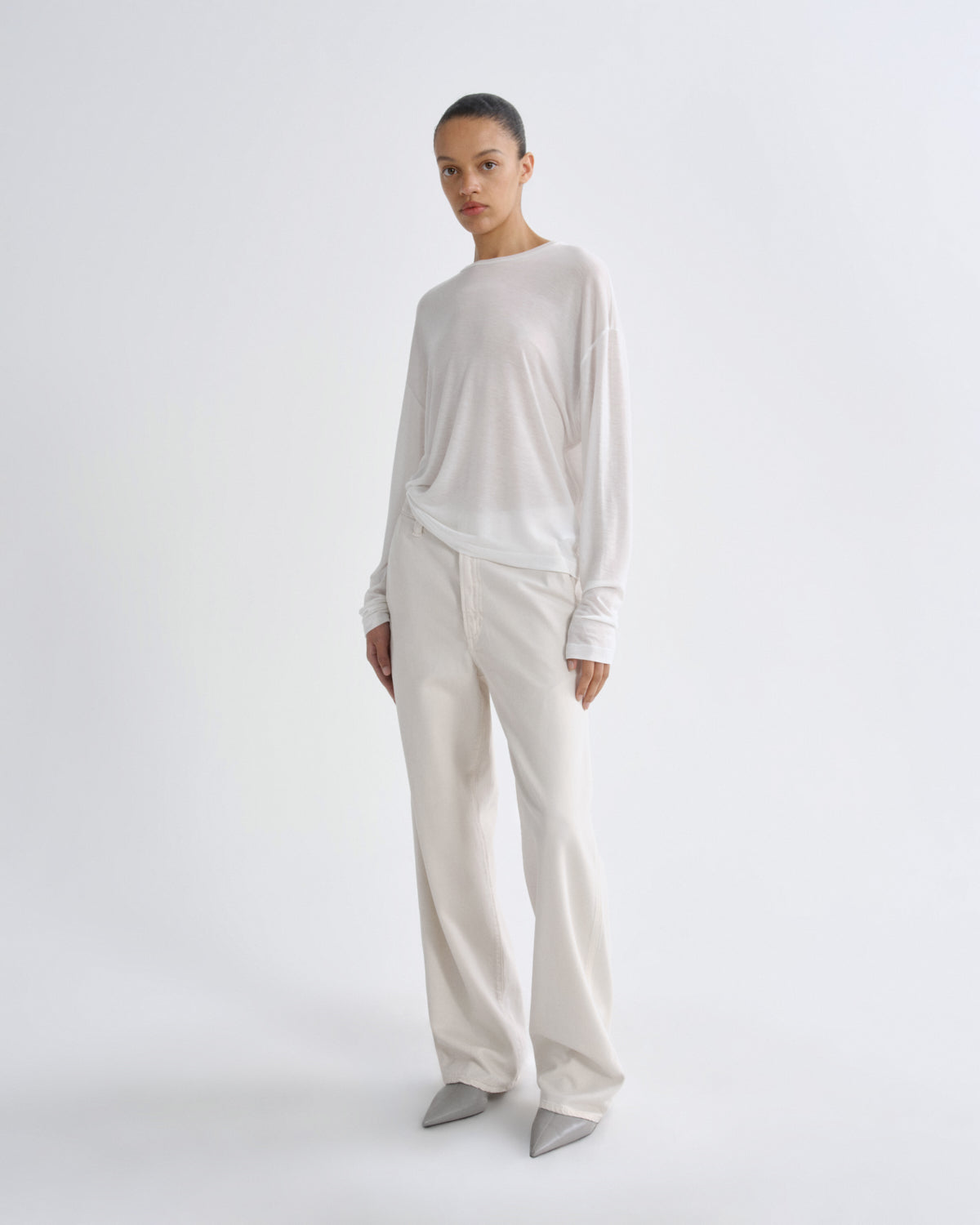 Person wearing a white long-sleeve top and pants on a white background
