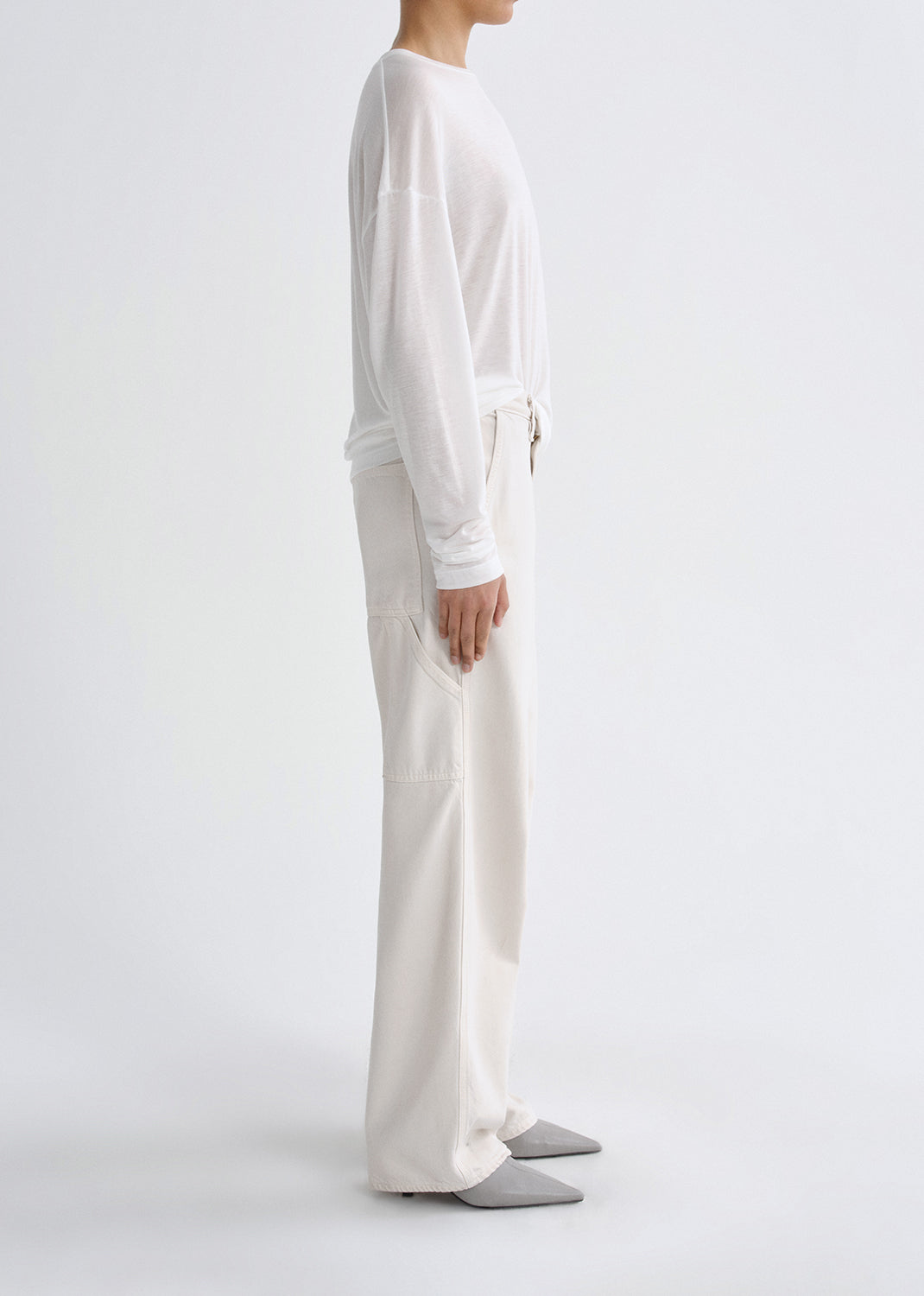 Person wearing white outfit on grey background