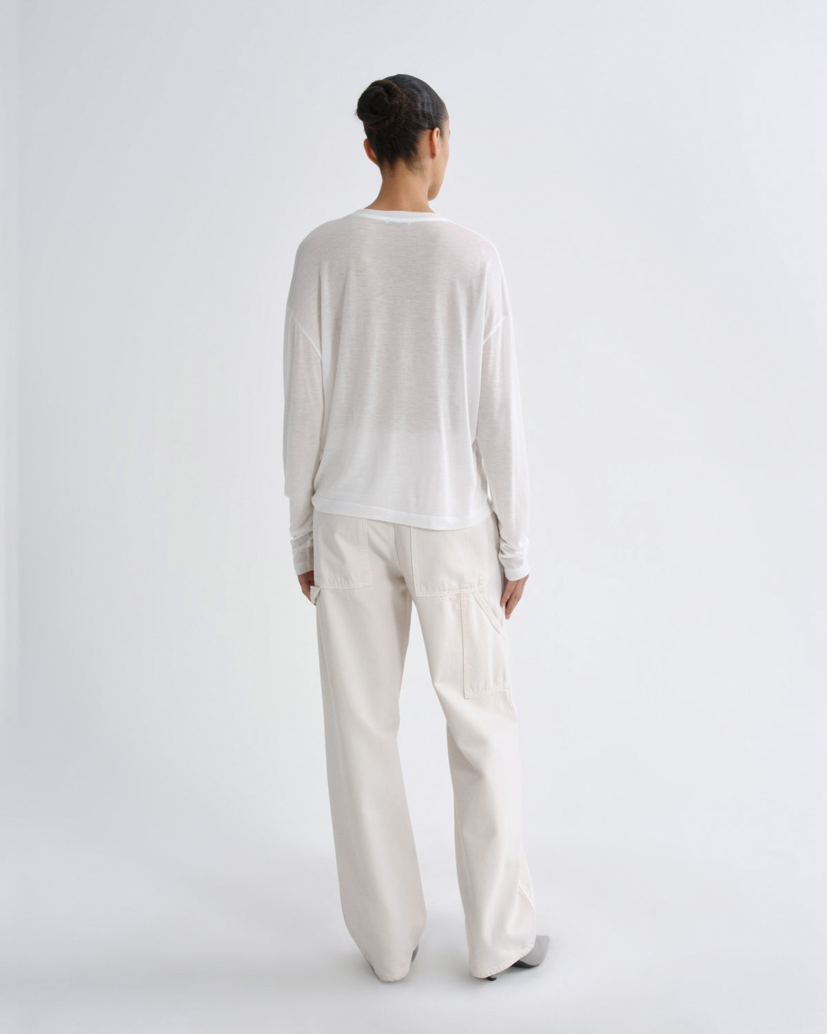 Person wearing a white outfit on a plain background