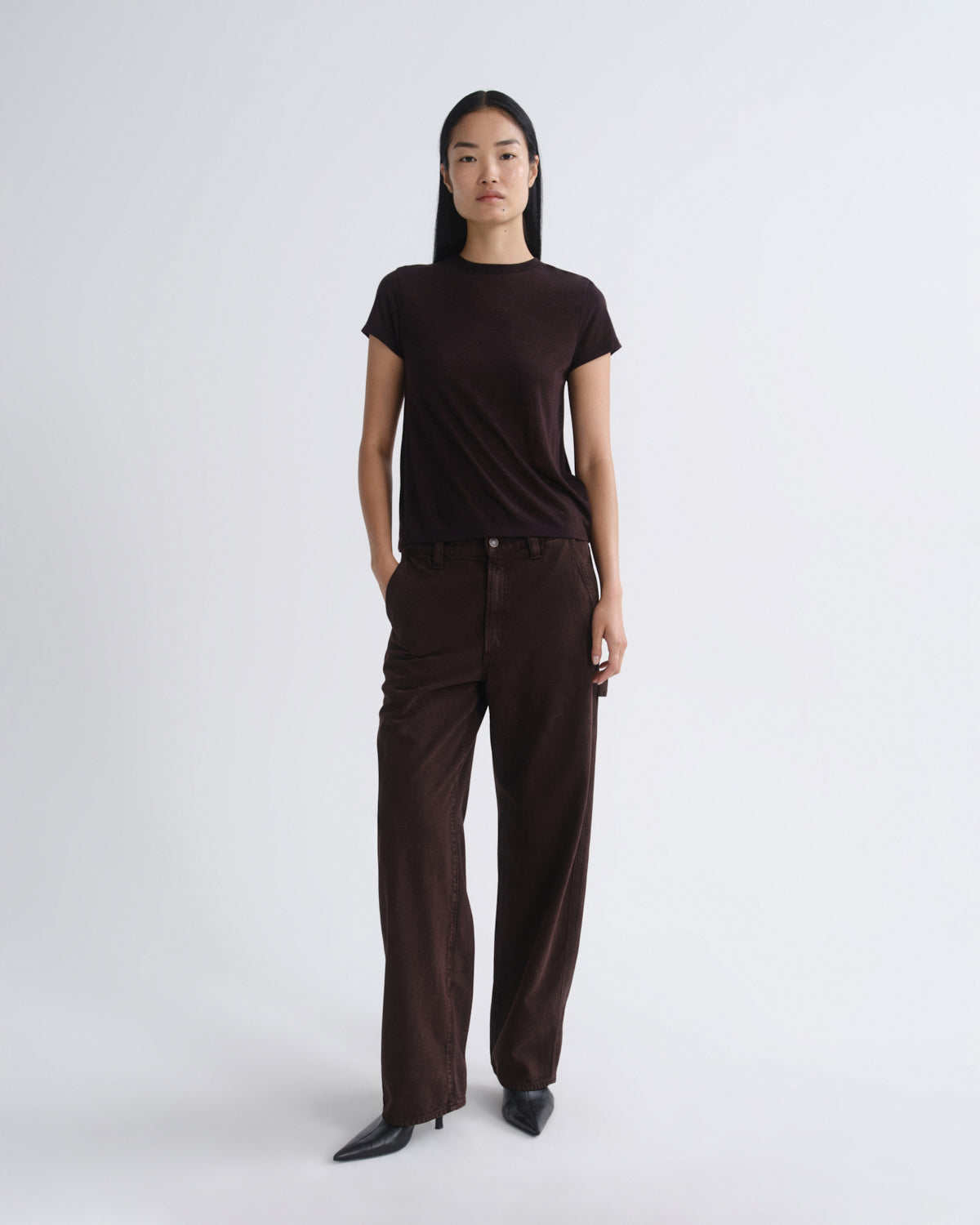 Person wearing a brown t-shirt and brown pants on a white background