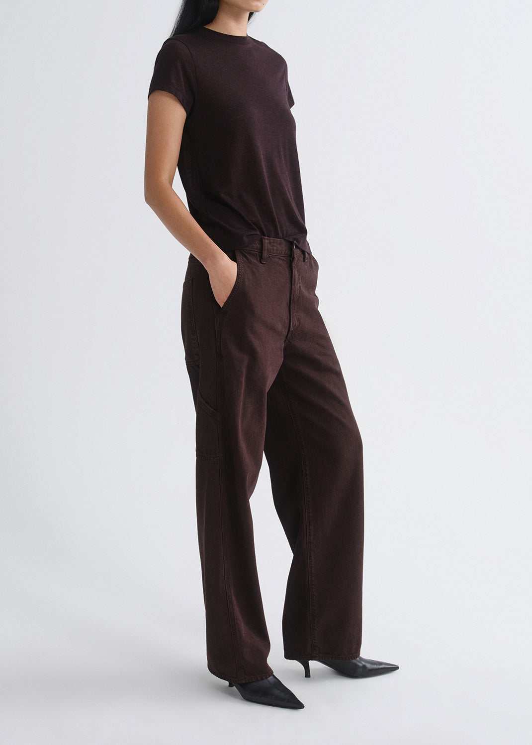 Person wearing a brown outfit on a grey background