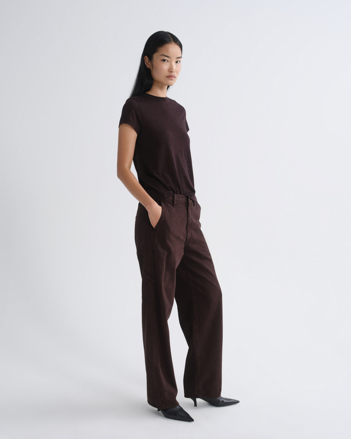Person wearing a brown t-shirt and brown pants on a white background