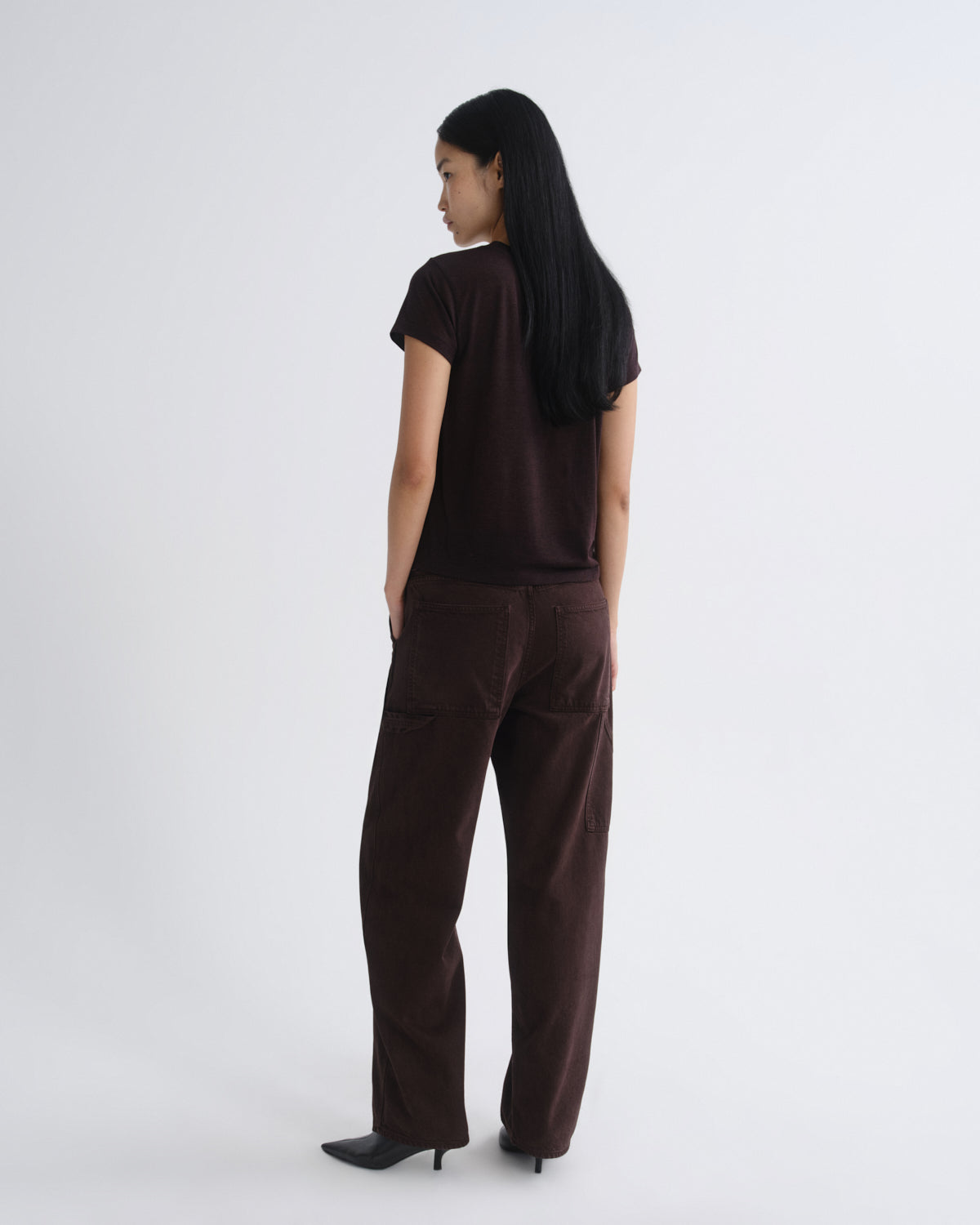 Person wearing a brown t-shirt and brown pants on a white background