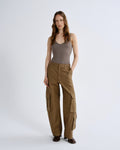Woman wearing a brown tank top and cargo pants on a white background