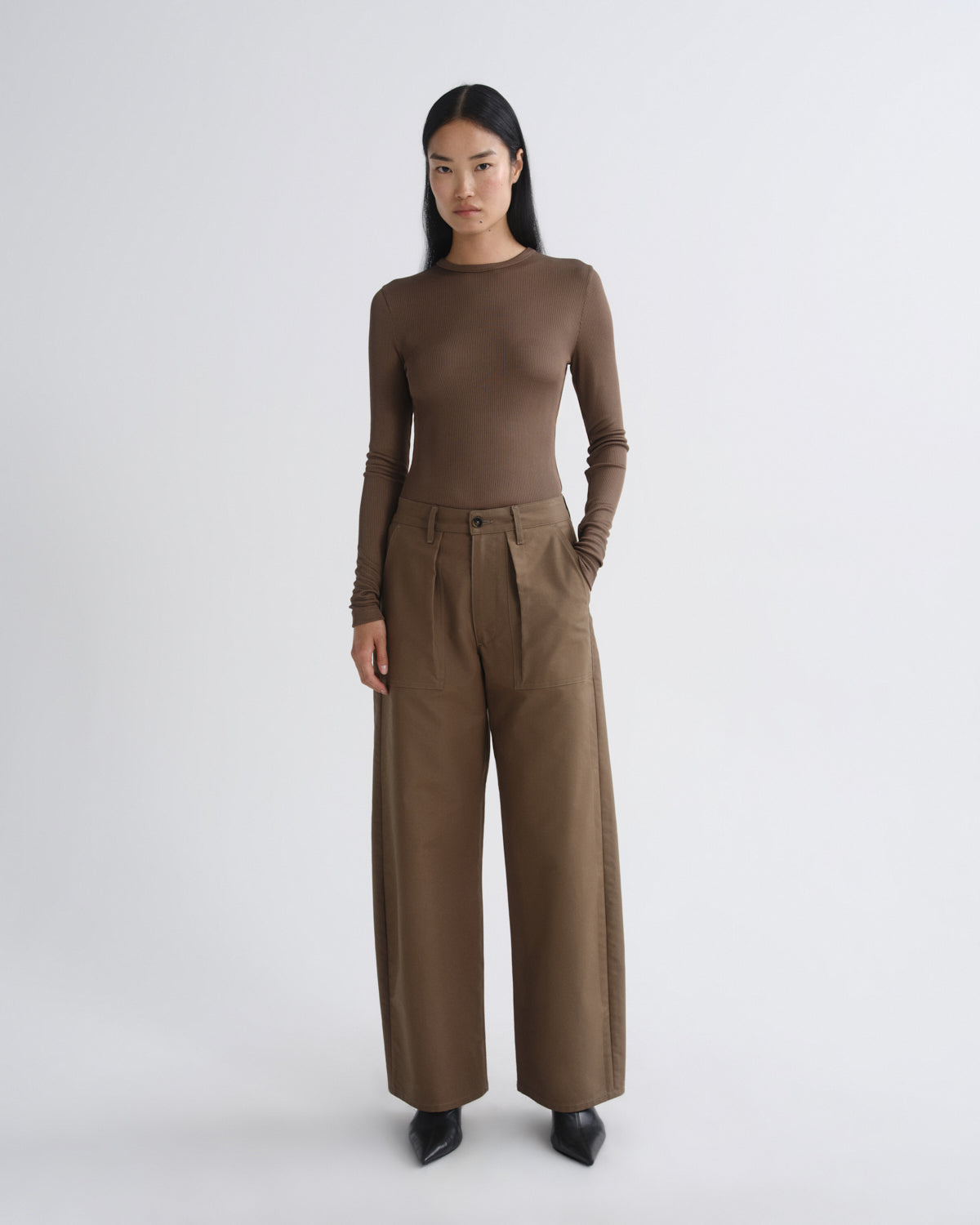 Woman wearing a brown outfit with wide-leg pants on a white background
