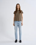 Woman wearing a brown t-shirt and light blue jeans on a white background