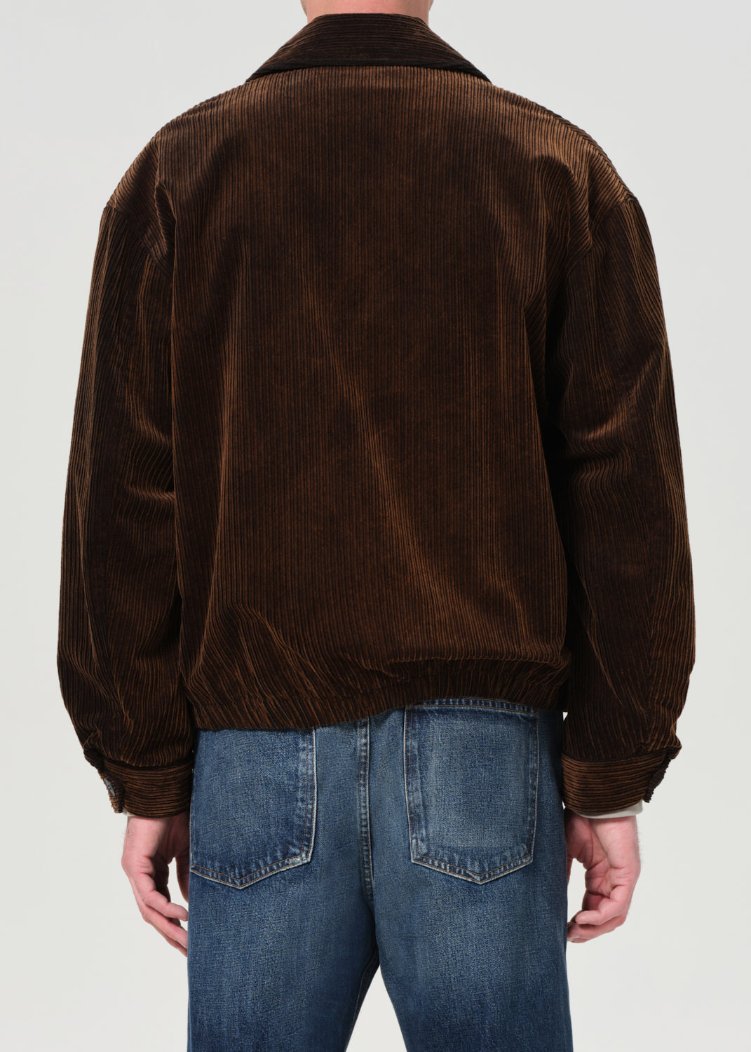 Brown corduroy jacket worn by a person on a white background
