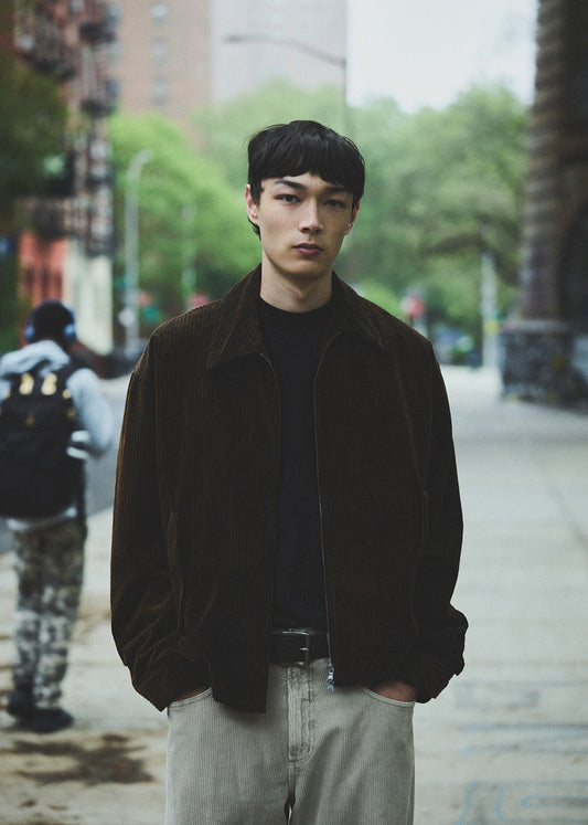 Man wearing a dark jacket and light pants on a city street