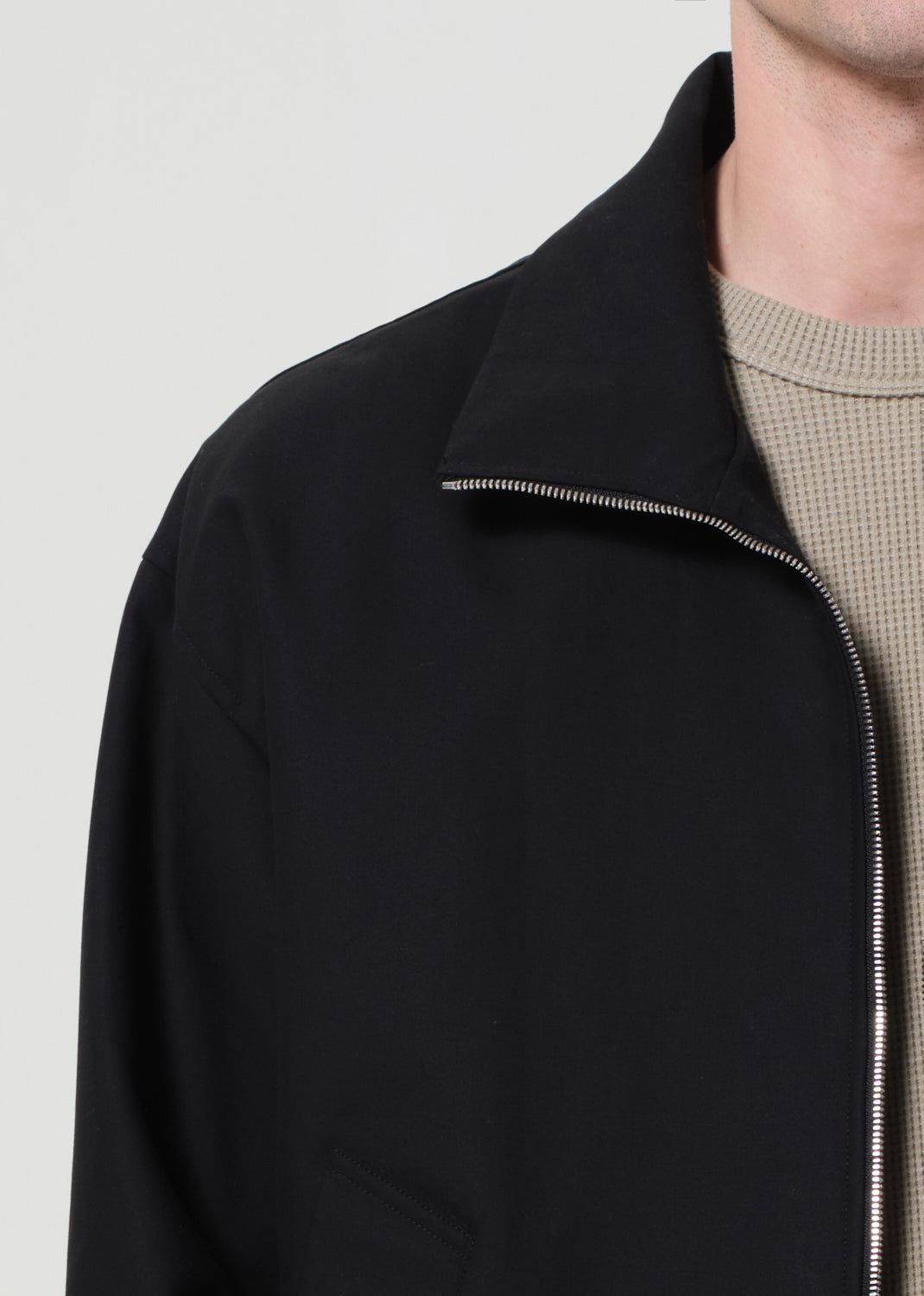 Black jacket with a zipper on a plain background