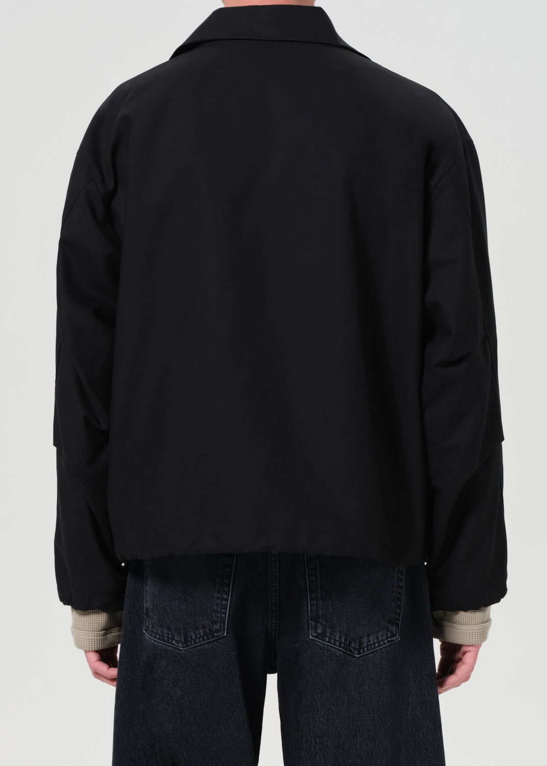 Black jacket worn by a person on a white background