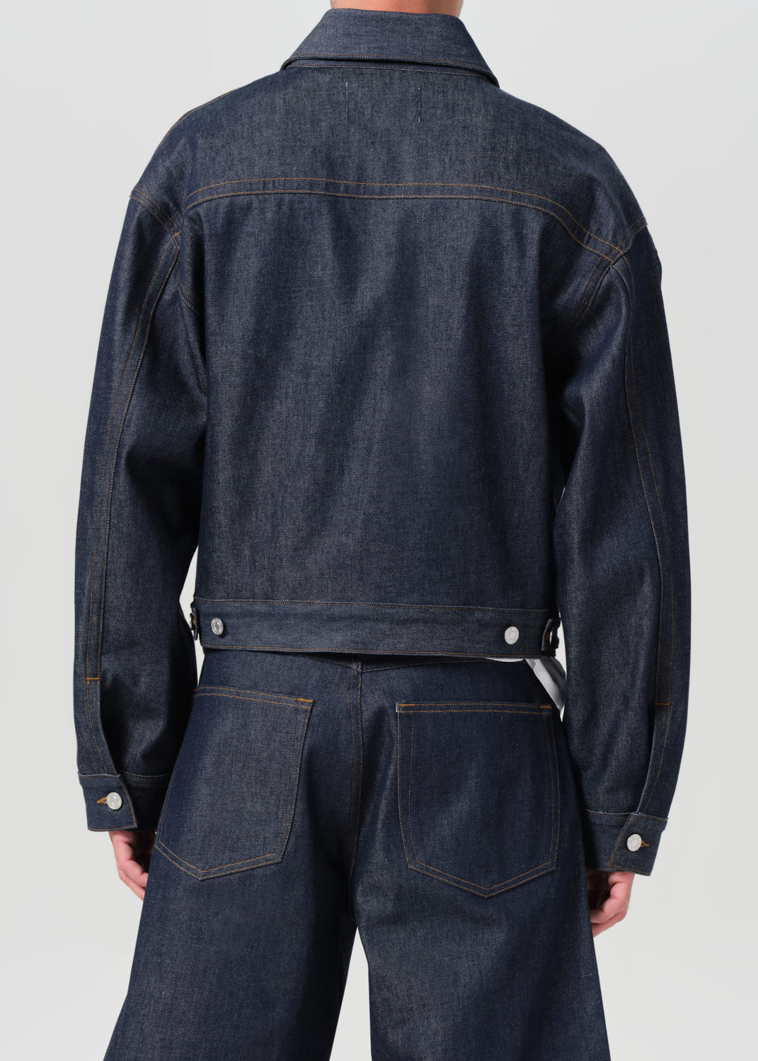 Dark blue denim jacket and pants on a plain background