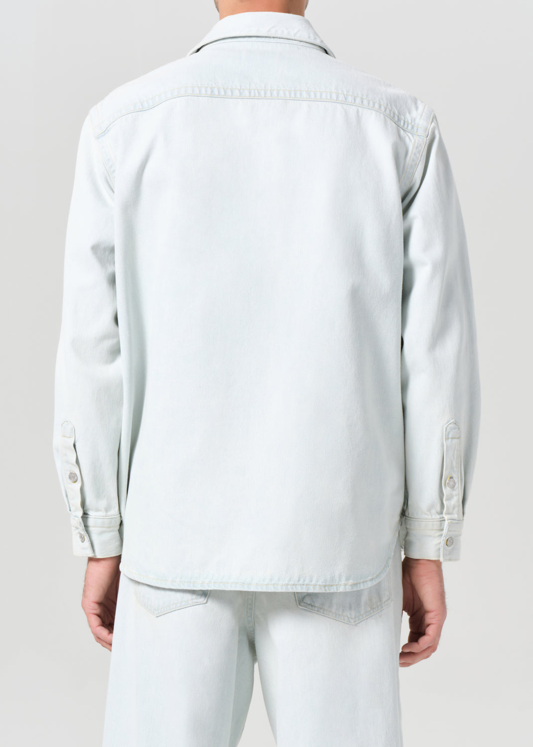 Light blue denim jacket worn by a person on a plain background