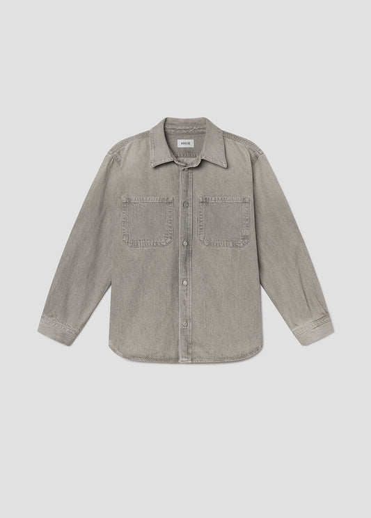 Flat lay of grey denim jacket on a light grey background
