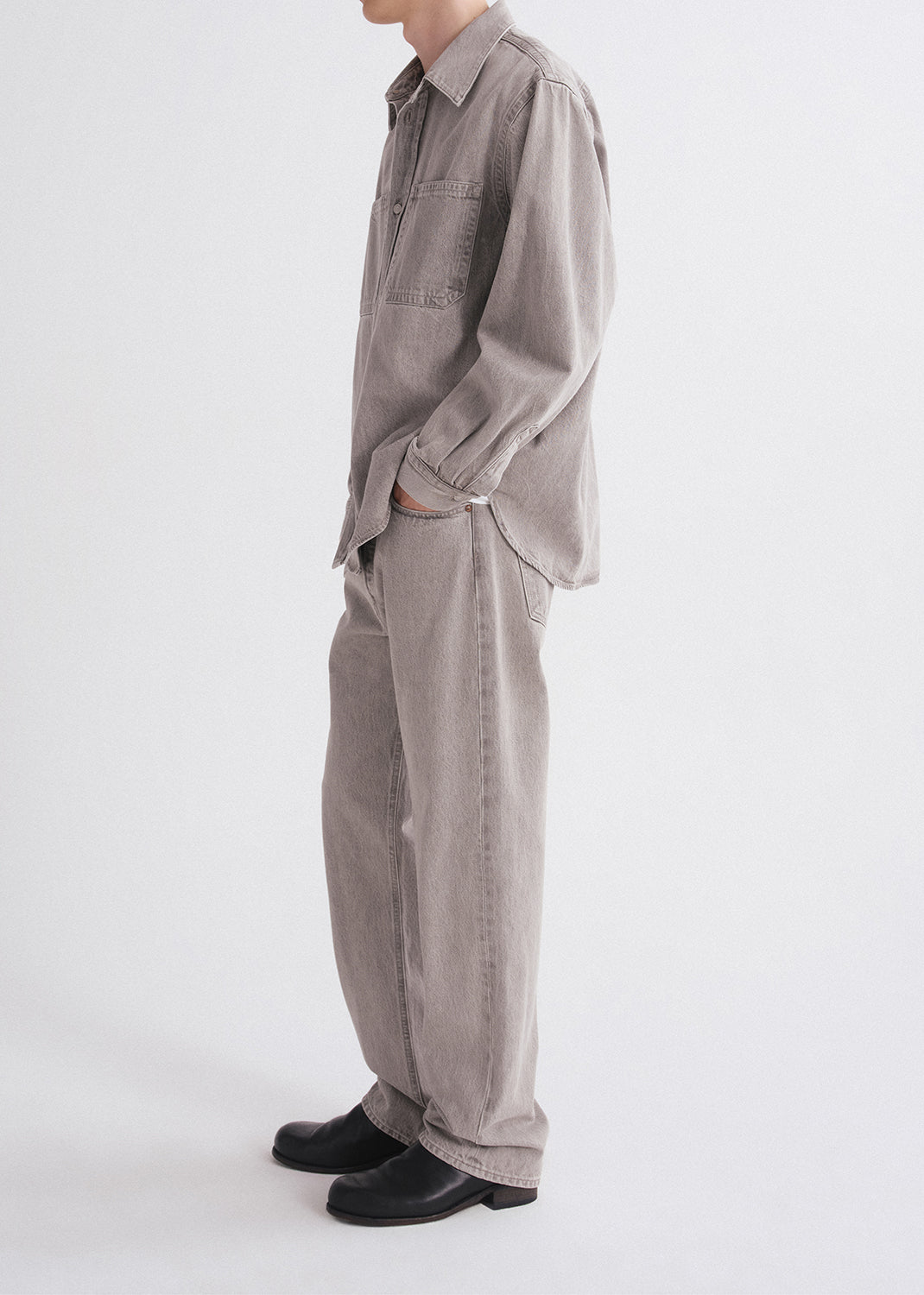 Person wearing a gray jumpsuit on a grey  background