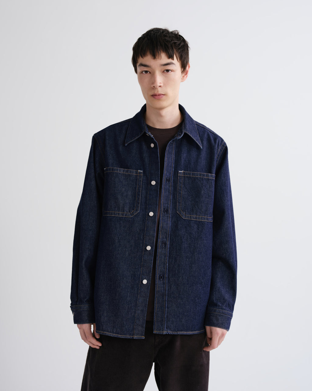 Man wearing a dark denim jacket on a white background