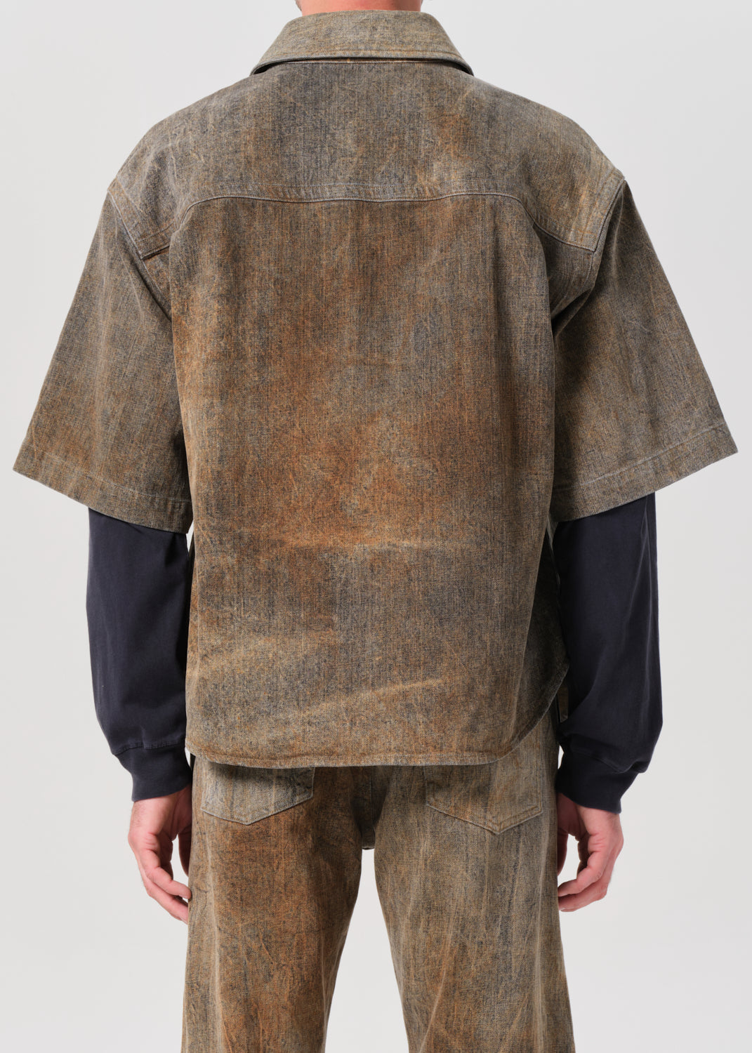 Brown textured jacket and pants worn by a person on a white background