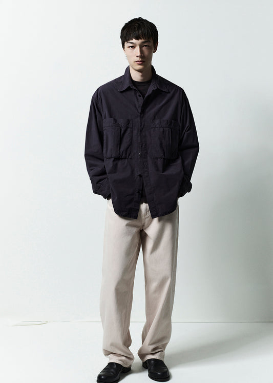 Person wearing a dark jacket and light pants against a white background