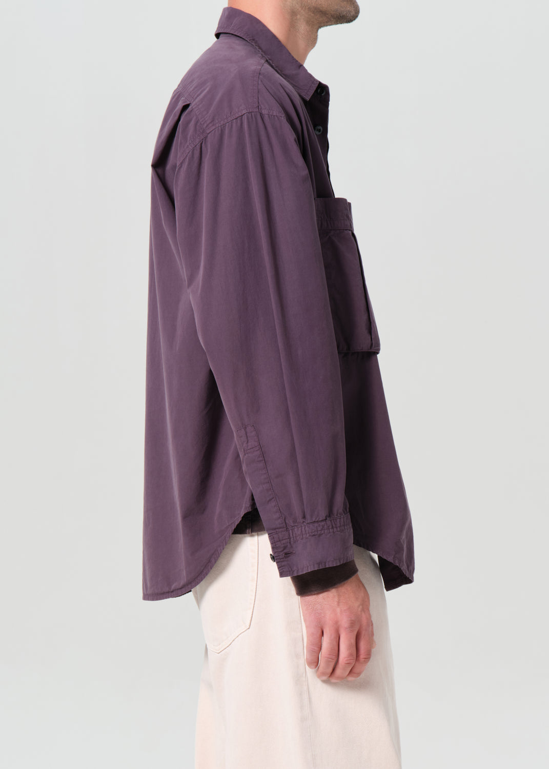 Person wearing a purple shirt with a plain background