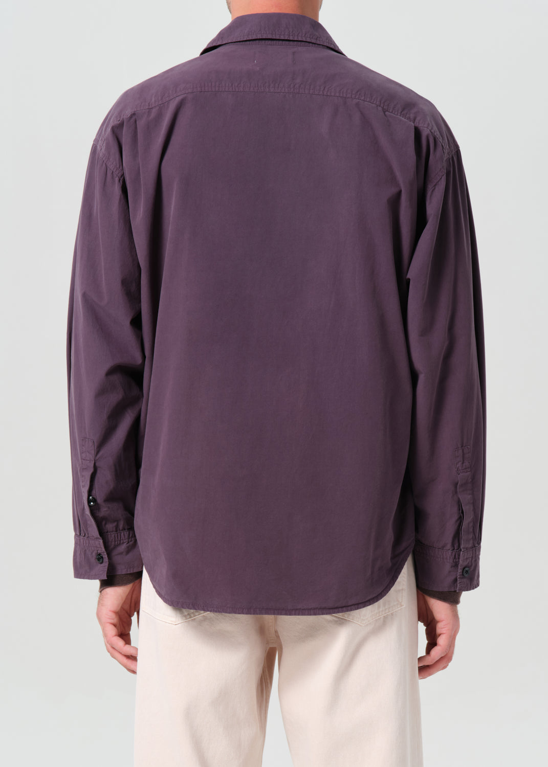 Purple shirt worn by a person on a plain background