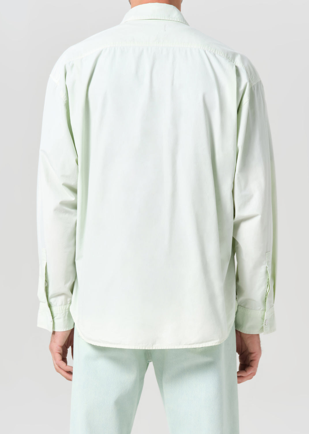 Light green jacket with white shirt and pants on a plain background