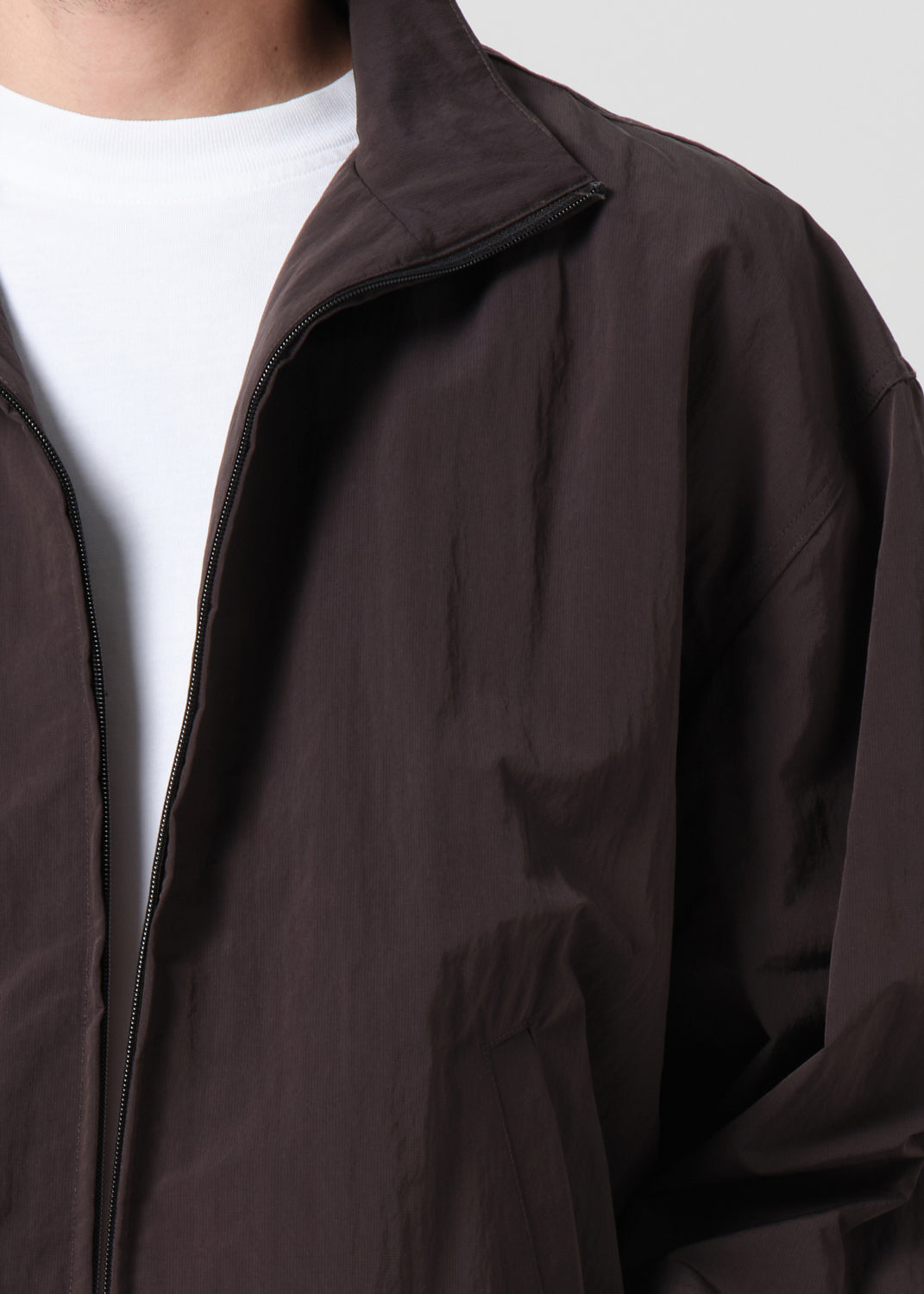 Brown jacket over a white shirt on a plain background