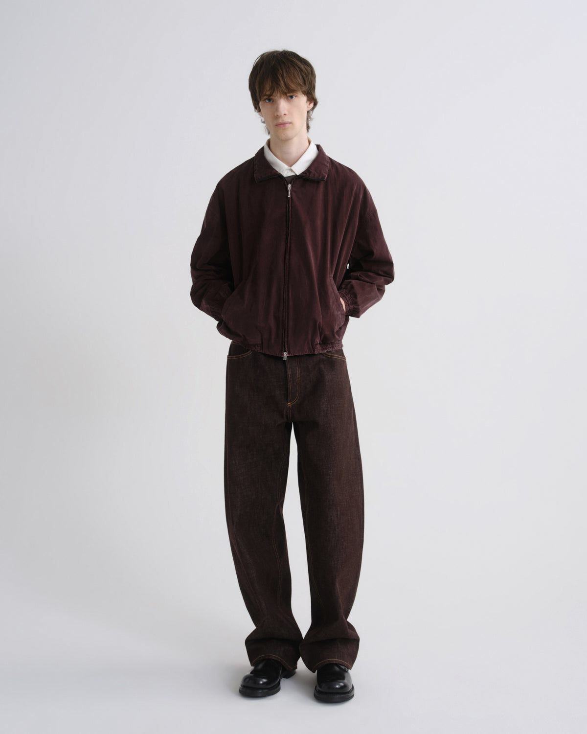 Person wearing a brown tracksuit on a white background