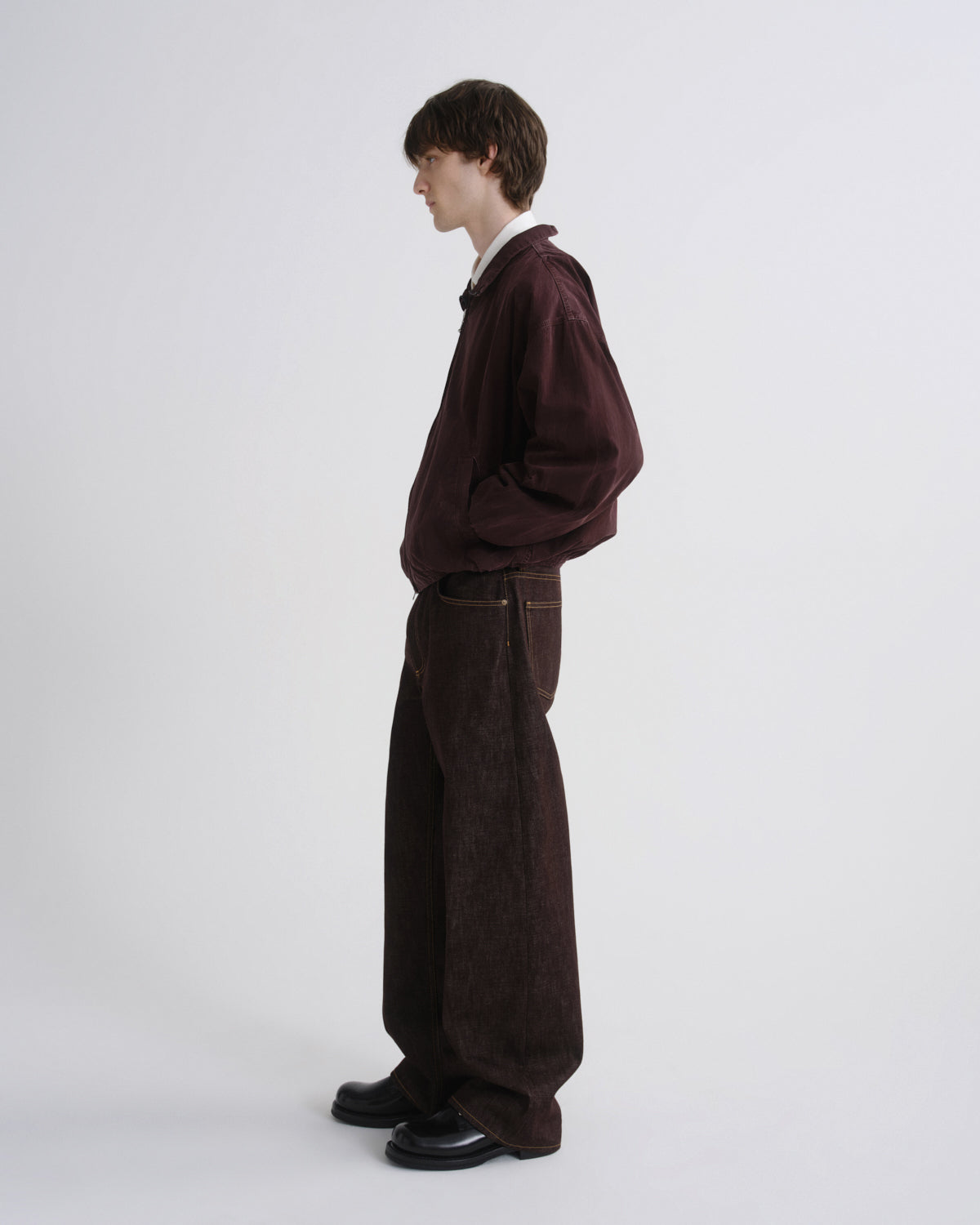 Person wearing a dark brown outfit on a white background