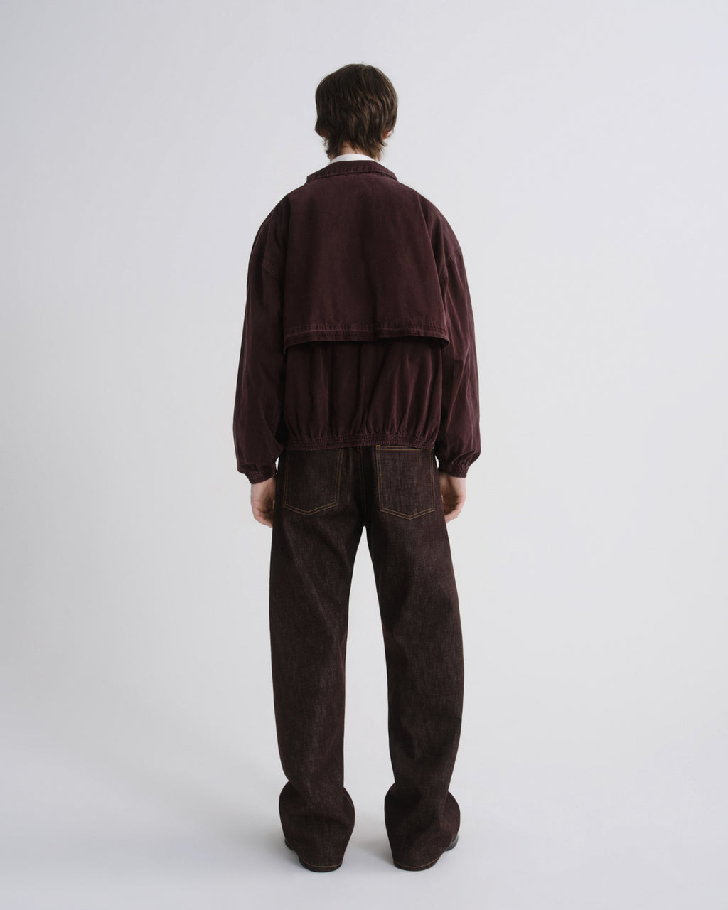 Person wearing a brown tracksuit on a white background