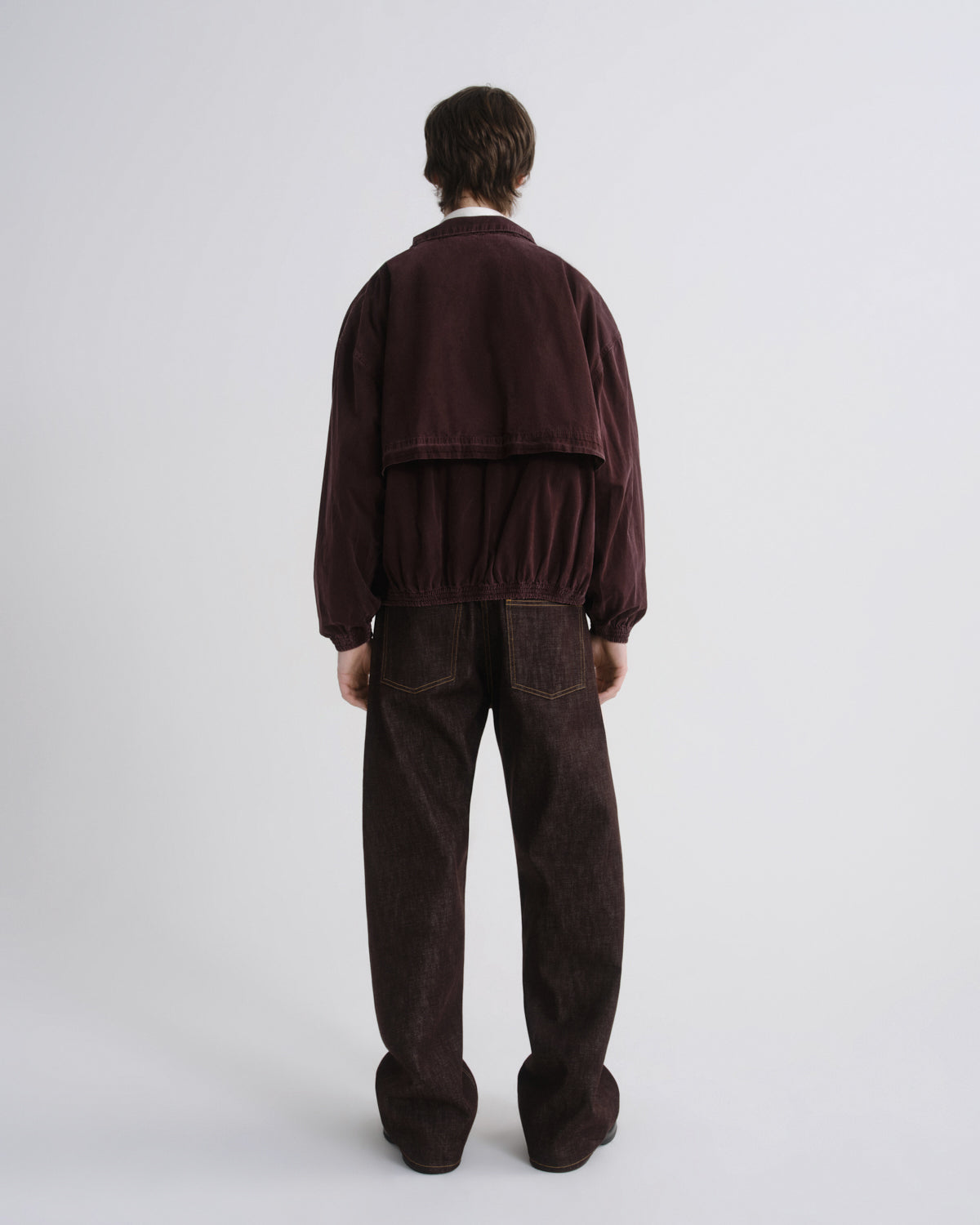 Person wearing a brown tracksuit on a white background
