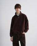 Person wearing a brown jacket and pants on a white background