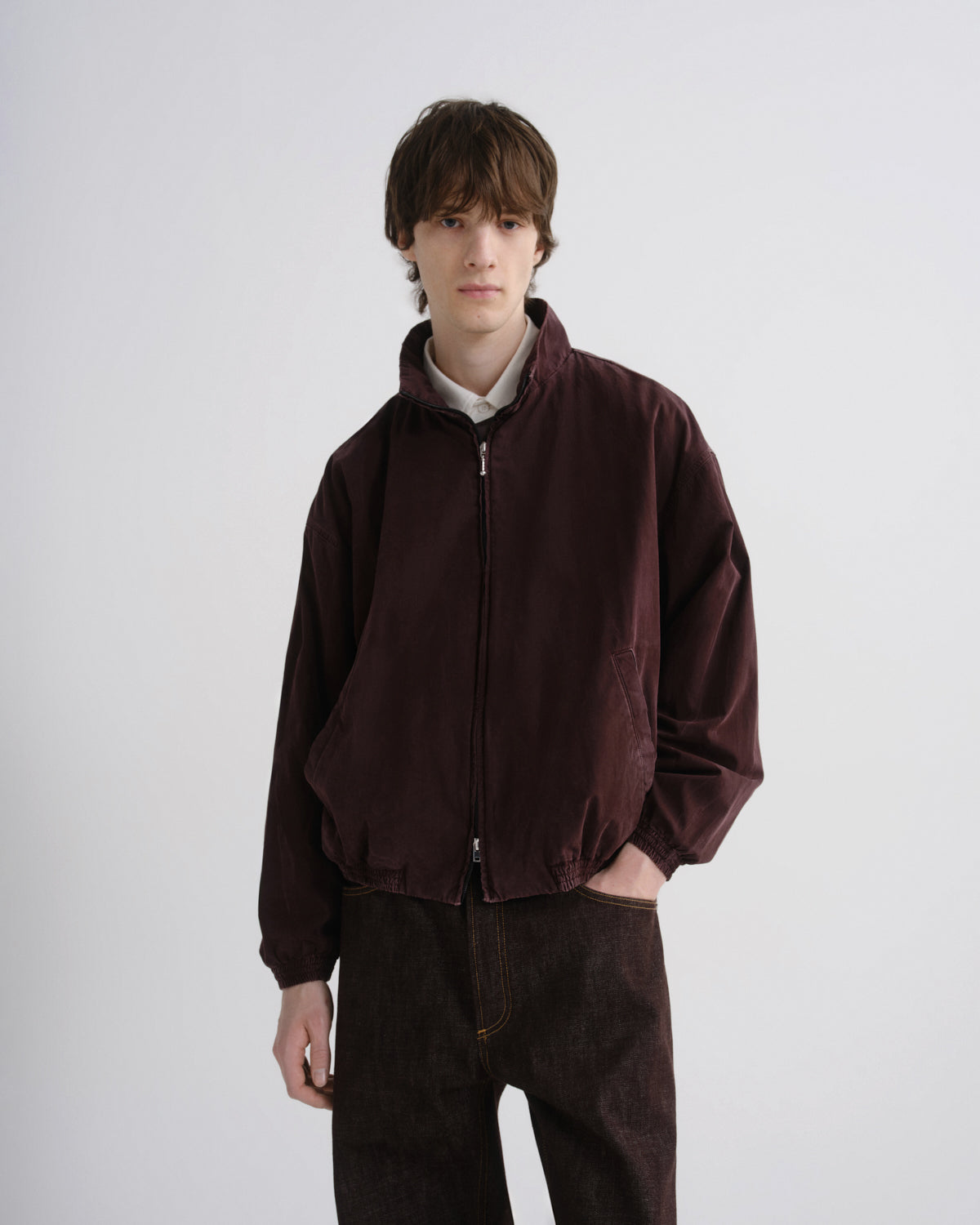 Person wearing a brown jacket and pants on a white background