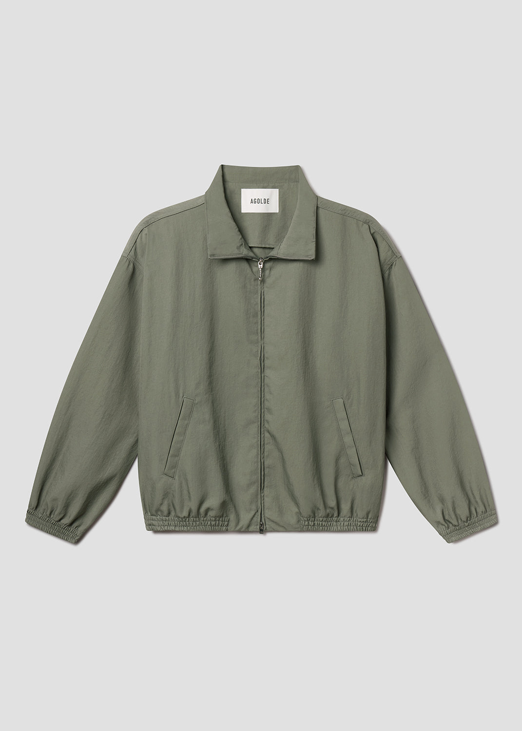 Flat lay of green jacket on grey background