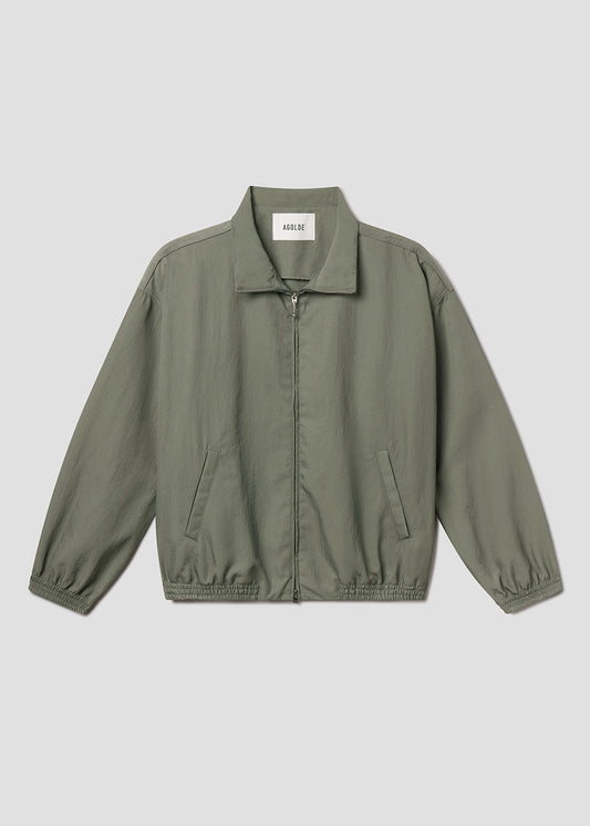 Flat lay of green jacket on grey background