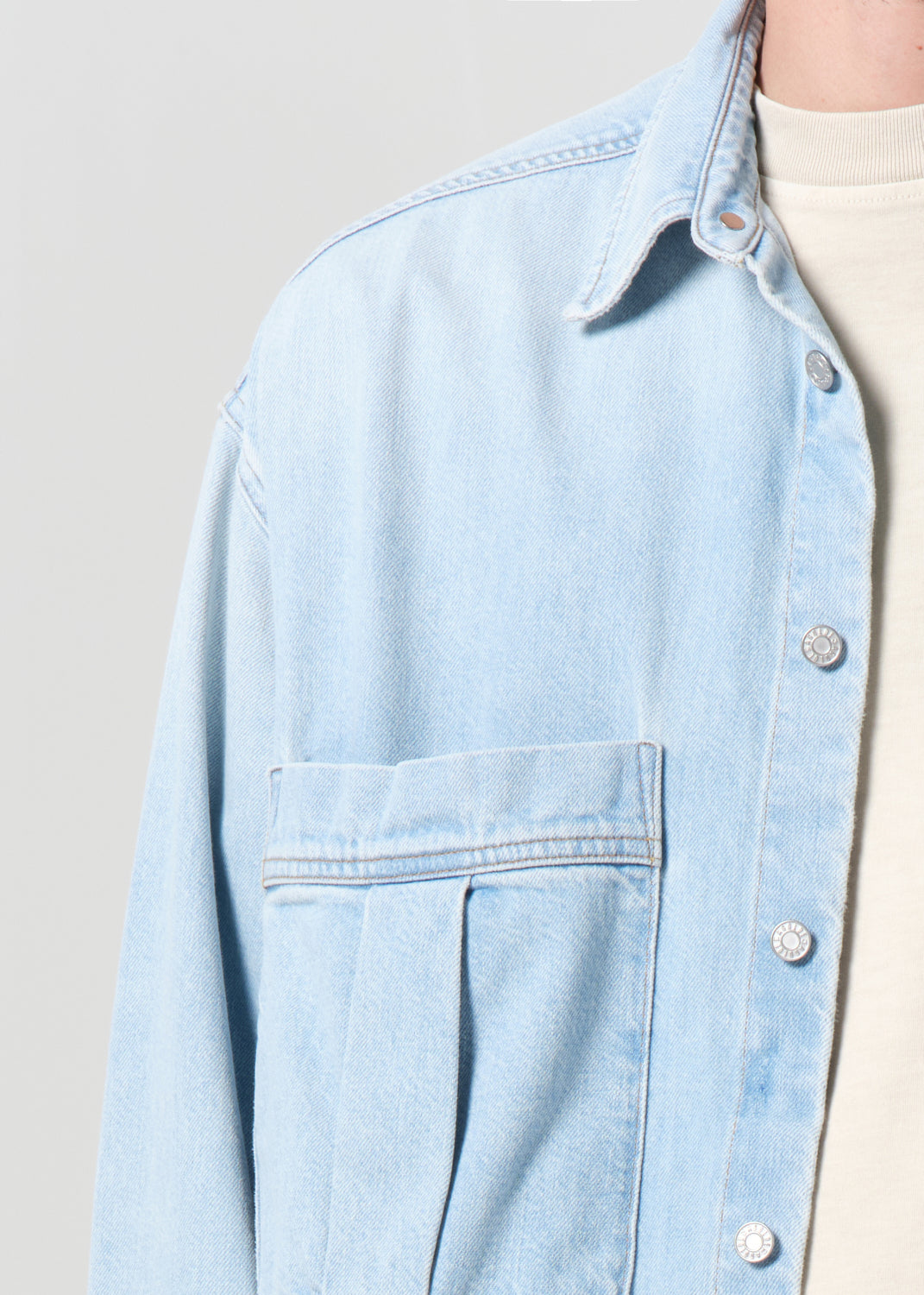 Light blue denim jacket on a neutral background