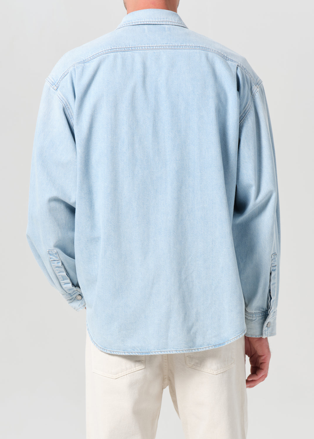 Light blue denim jacket worn by a person on a plain background