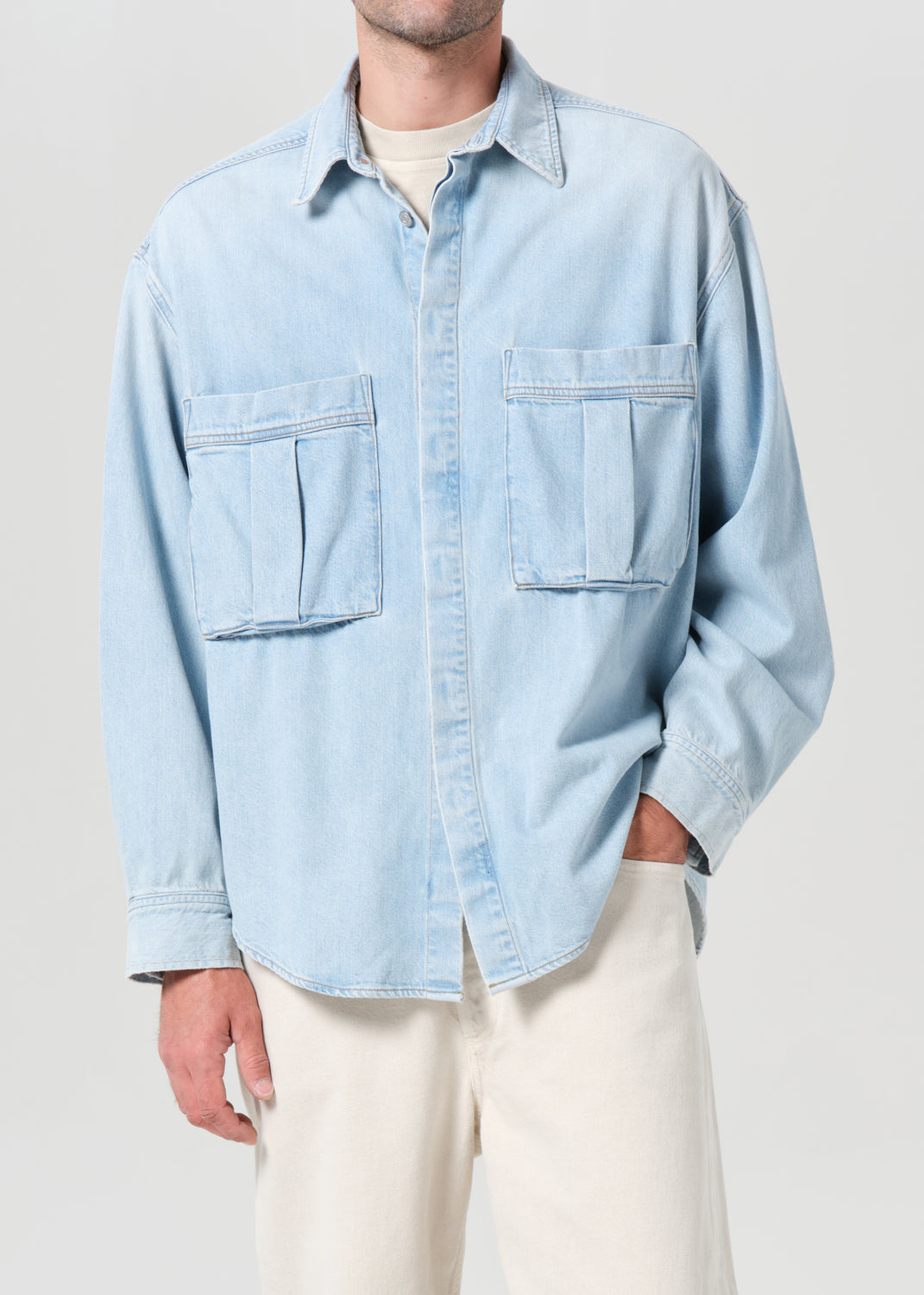 Light blue denim shirt worn by a person on a plain background