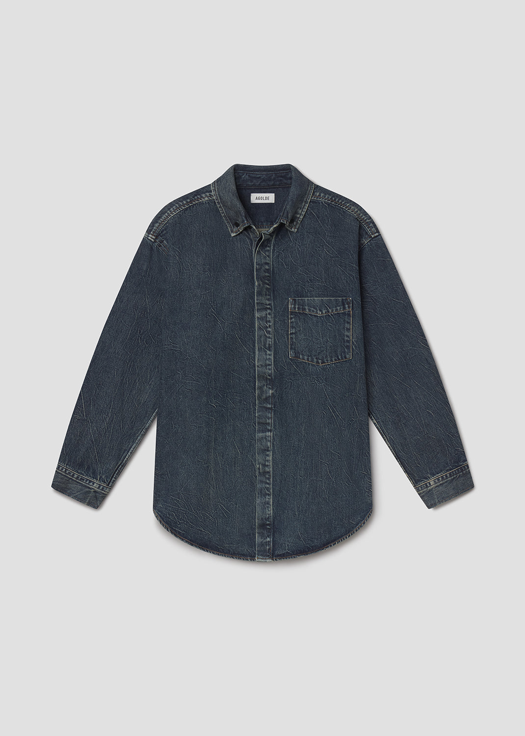 A dark blue denim long-sleeve button-up shirt with a chest pocket, laid flat against a grey background.